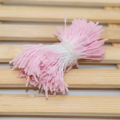 A bundle of pink and white glittery plastic mini flower stamen hair ties for kids bedroom use