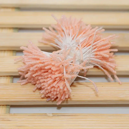A cluster of peach-colored glittery artificial coral mini flower stamen hair ties with white stems for kids bedroom