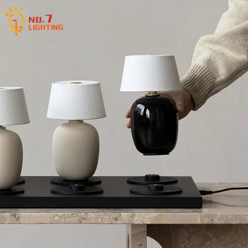 Glossy black ceramics table lamp with white fabric shade suitable for bedroom lighting and decor