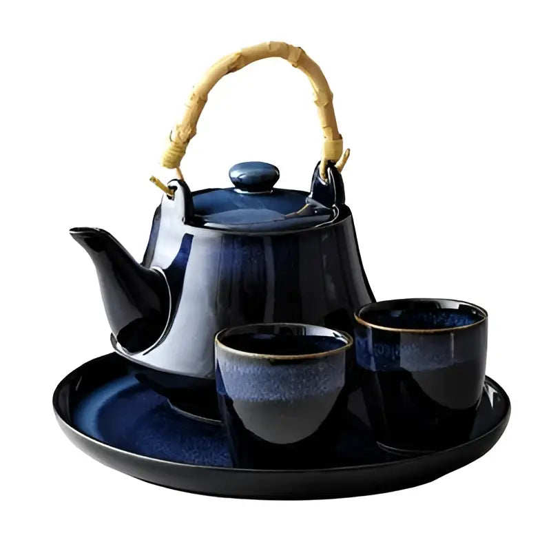Glossy deep blue ceramic tea kettle set with bamboo handle and matching cups on a coordinating tray for dining decorbites blue ceramic