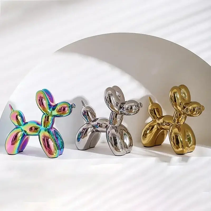 Three glossy balloon dog ceramic figurines in iridescent rainbow, chrome silver, and gold finishes for living room decor