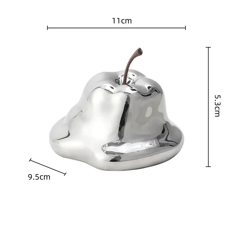 Shiny silver metallic apple-shaped decor with brown stem complementing decorbites abstract melting apple sculpture