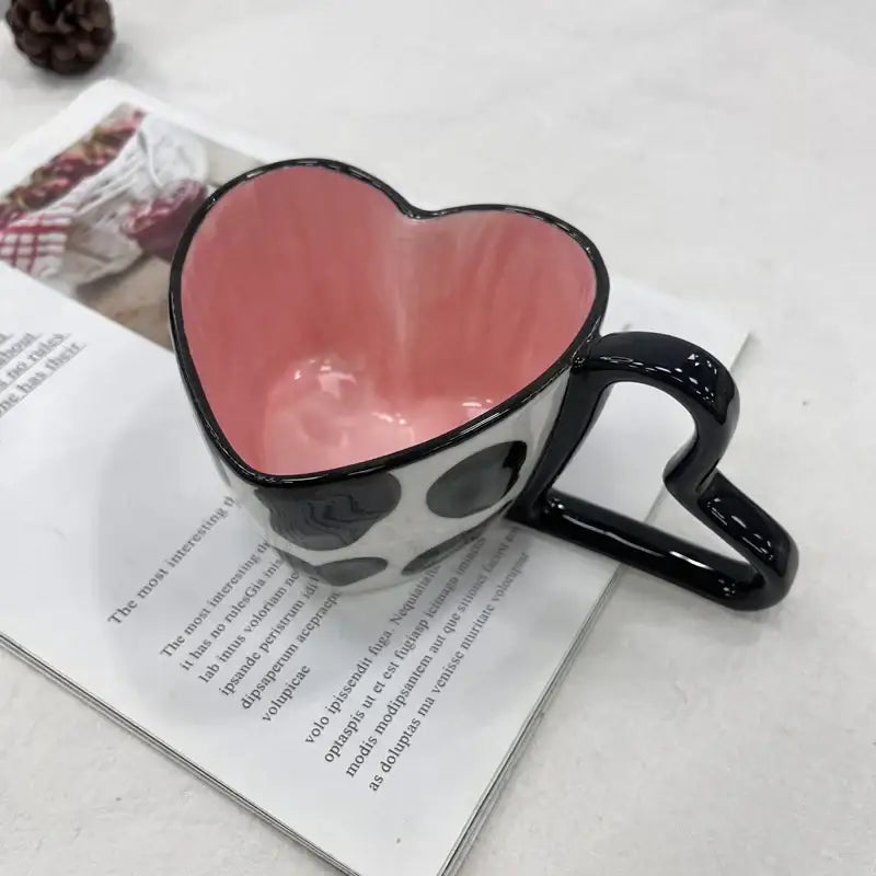 Glossy black heart shape ceramic coffee mug with pink interior and white polka dot exterior by decorbites heart shape