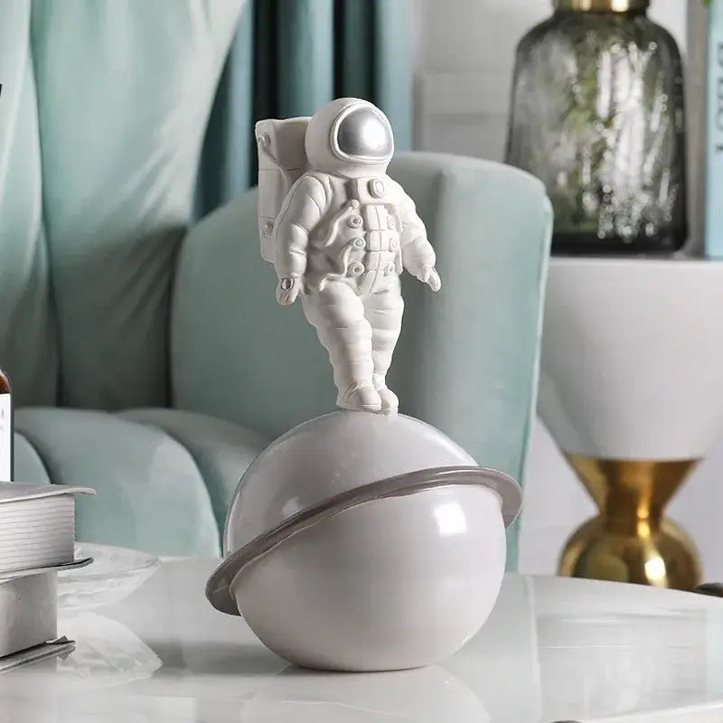 Glossy white and gold astronaut phone holder featuring a white astronaut figurine on a glossy white planet with gray ring