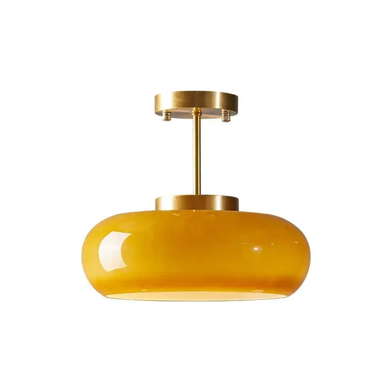 A sleek amber glass led pendant light with polished brass finish for kitchen or dining room pendant lights