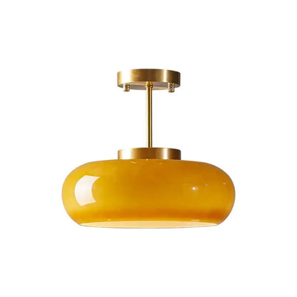 A sleek amber glass led pendant light with polished brass finish for kitchen or dining room pendant lights