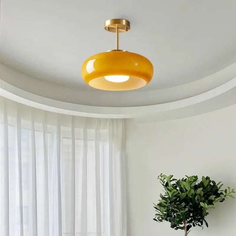 Glossy yellow glass ball led pendant light with polished brass fixture ideal for kitchen or dining room pendant lights