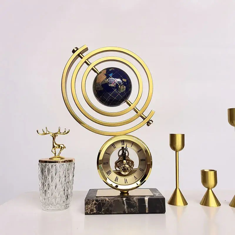 Gold and blue clock globe decoration with dark blue world map sphere encased in brass rings on black marble base