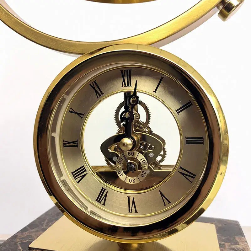 Golden skeleton clock with roman numerals and exposed gears on marble base for clock globe decoration decorbites clock globe
