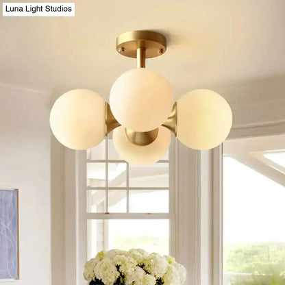 Gold-toned semi-flush mount ceiling light with four opaline glass globe shades compatible with 220v-240v 110v-120v