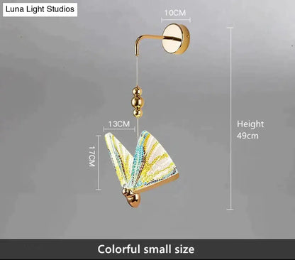 Gold and patterned butterfly led wall light with gold finish and colorful yellow and teal wings for bedroom decor