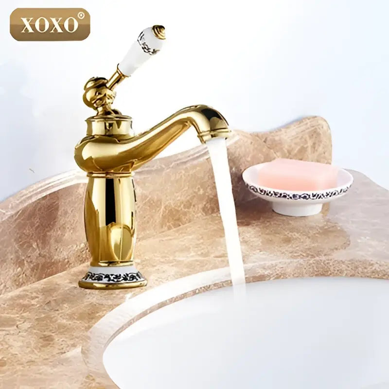 Gold and white ceramic bathroom basin faucet deck mounted mixer with ornate detailing and xoxo brand logo from decorbites bathroom basin
