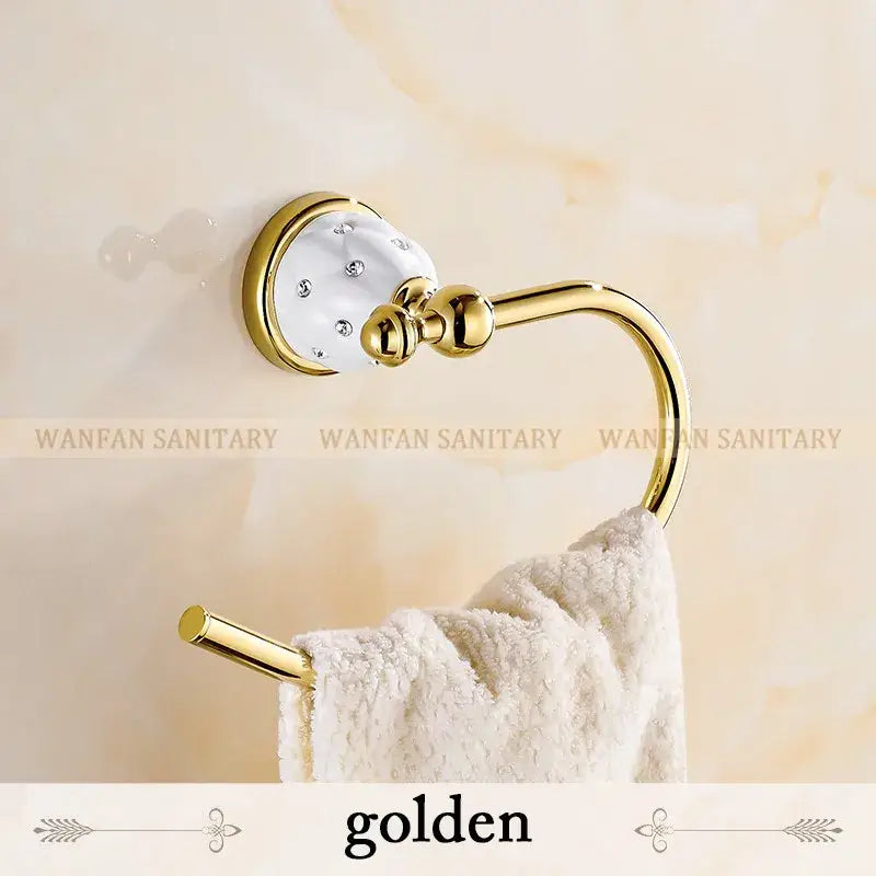 Golden towel ring with white ceramic head and clear crystals in polished brass finish for bath hardware set
