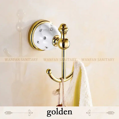 Golden bathroom hook with white ceramic base clear rhinestones and polished brass accents in bath hardware set