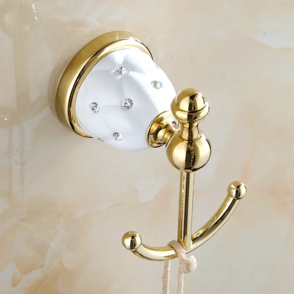 Gold-toned bathroom hook with white crystal-embellished ceramic base in a polished bath hardware set design