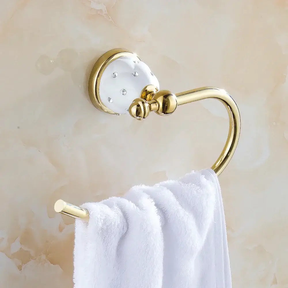 Gold and white crystal bath hardware set featuring a gold-toned towel rack with clear rhinestones and a white towel
