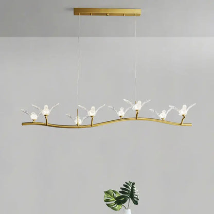 Gold bird branch LED pendant lamp with gold-toned curved branch and six crystal bird figures, adjustable chain cord length
