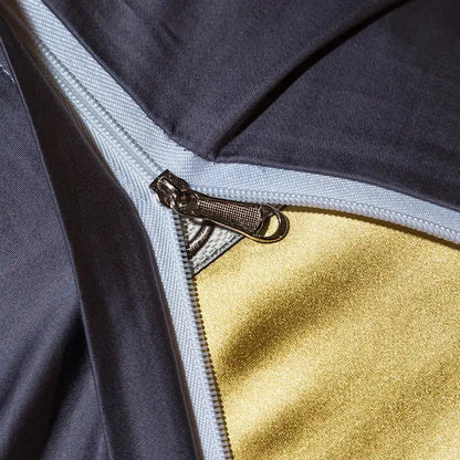 A metallic zipper with a textured pull tab on gold and black 200s embroidery egyptian cotton bedding set fabric layers