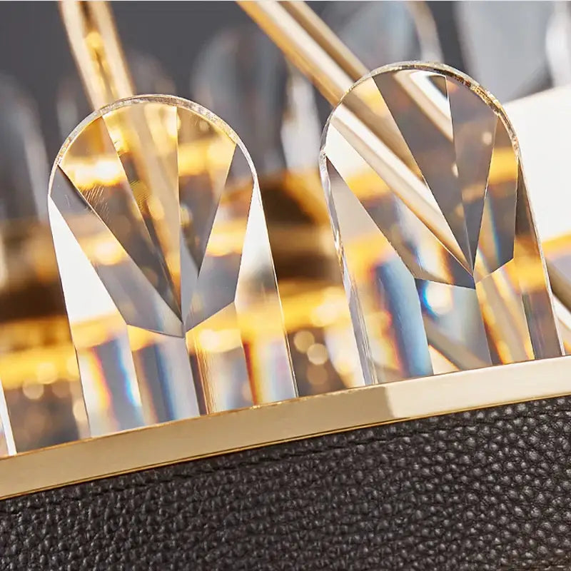Gold and black crystal oval chandelier dining room light featuring gold-framed crystal embellishments on leather strap