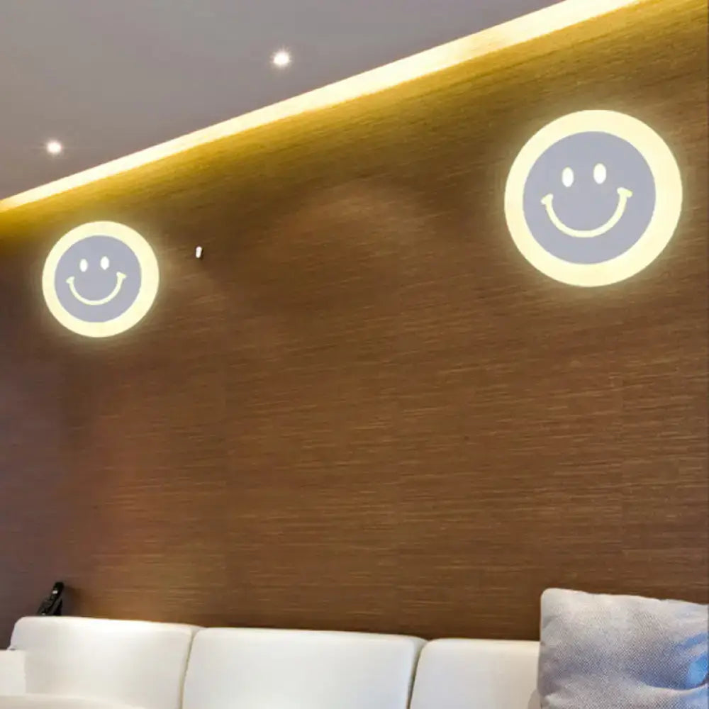 Two gold and brown crescent led wall lights with smiling faces emitting warm glow for children’s bedroom wall light