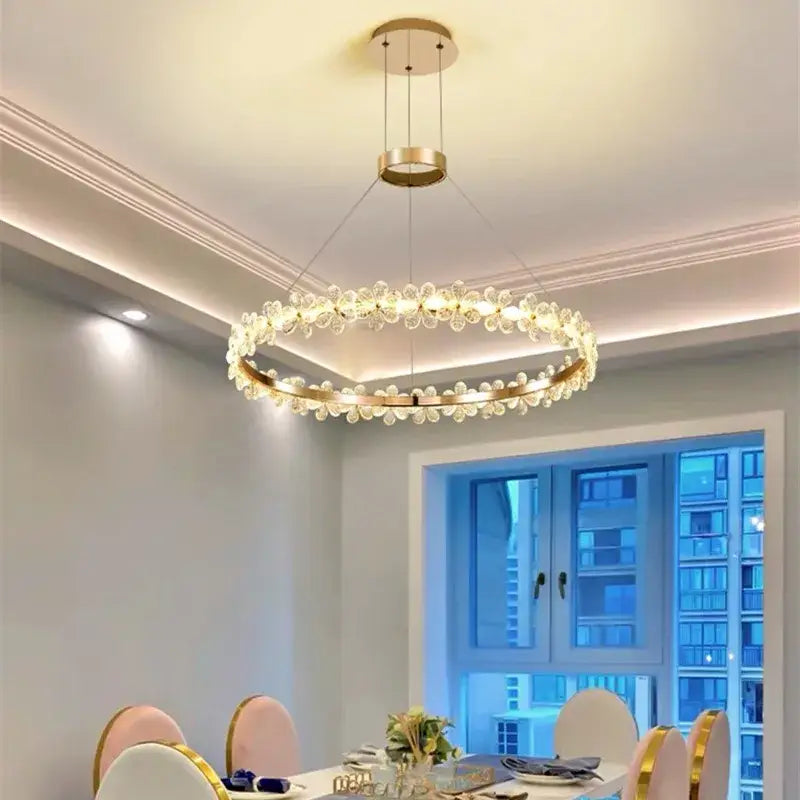 A modern gold-toned decorbites crystal led chandelier with clear flower-shaped crystals for living room decor