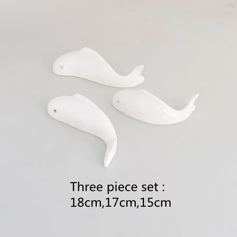 Set of three white ceramic whale figurines with glossy finish and metallic eyes complementing decorbites carp fish lotus wall art
