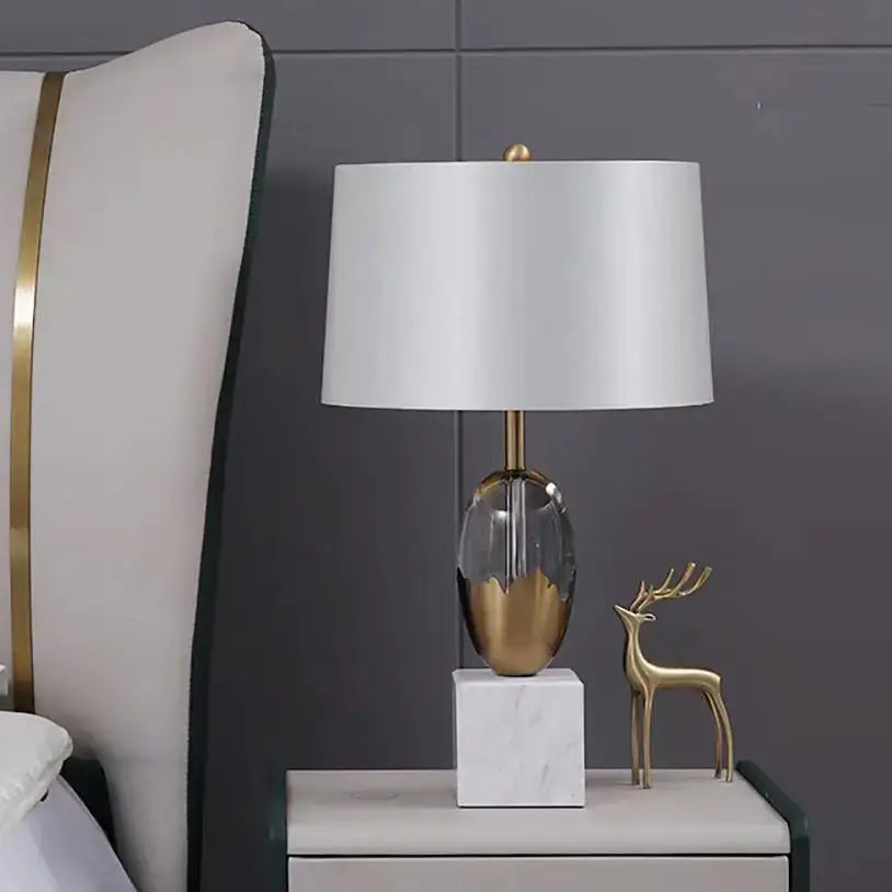 Modern fabric table lamp with white shade gold-toned crystal fabric base and marble pedestal for bedroom decor