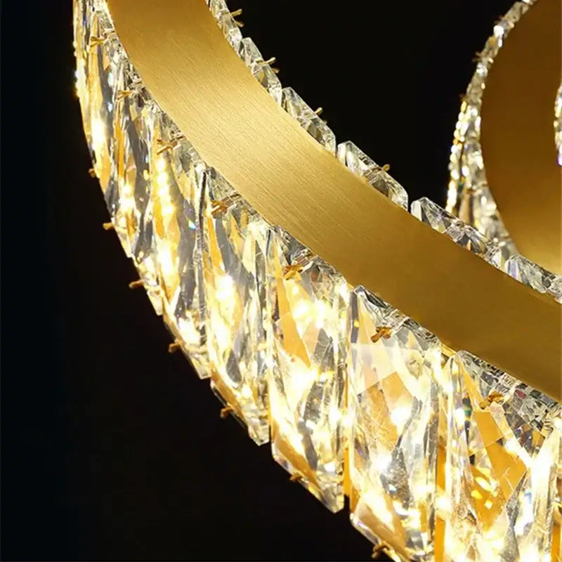 A gold circular decorbites crystal led chandelier with sleek metal frame and cascading faceted crystal droplets