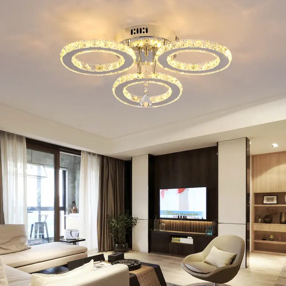 Gold crystal led rings ceiling chandelier with three interlocking crystal led rings and gold-toned metal decorbites crystal led