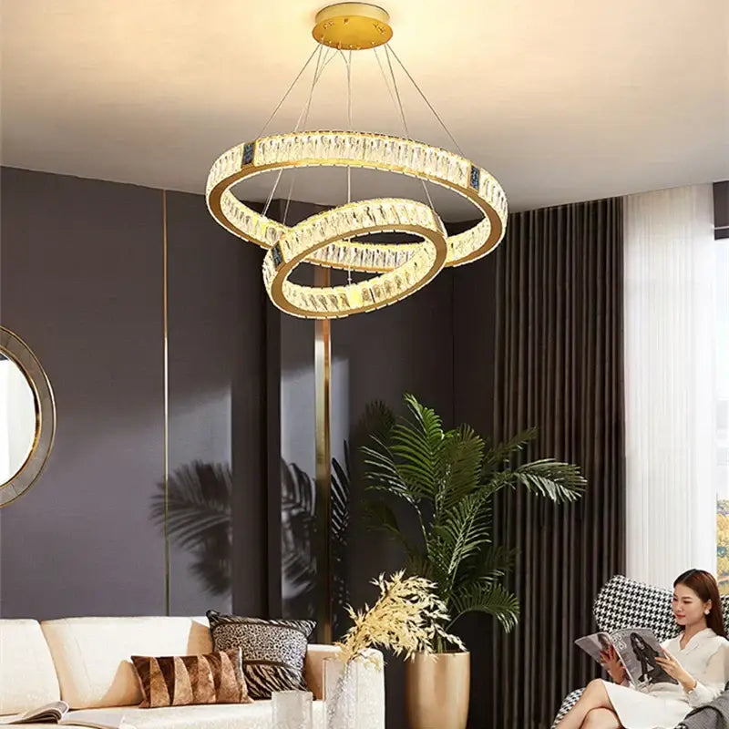 Gold decorbites crystal round ceiling chandelier with gold-toned interlocking rings and clear crystals for dining room use