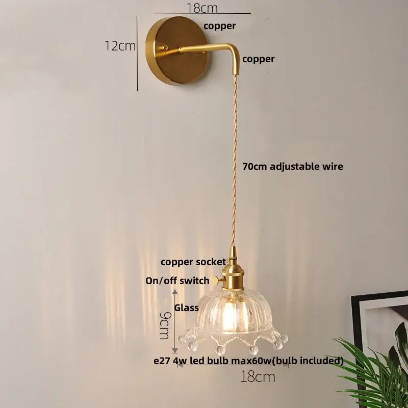 A brass-finished copper wall light with clear glass petal-shaped shade and adjustable 70cm wire for decorbites clear glass led lighting