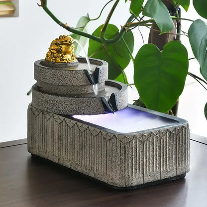 Three-tiered gray stone fish pond tank fountain with golden toad figurine flowing water and illuminated base garden ornament