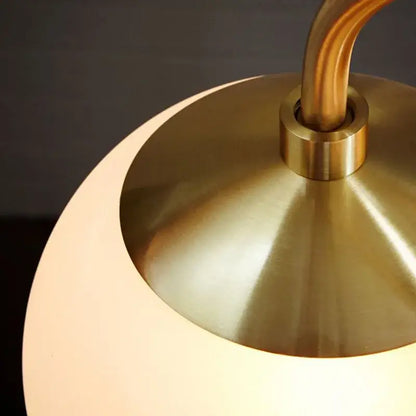 A warm gold frosted glass ball led pendant chandelier with brushed brass base and curved stem for kitchen lighting decorbites glass ball