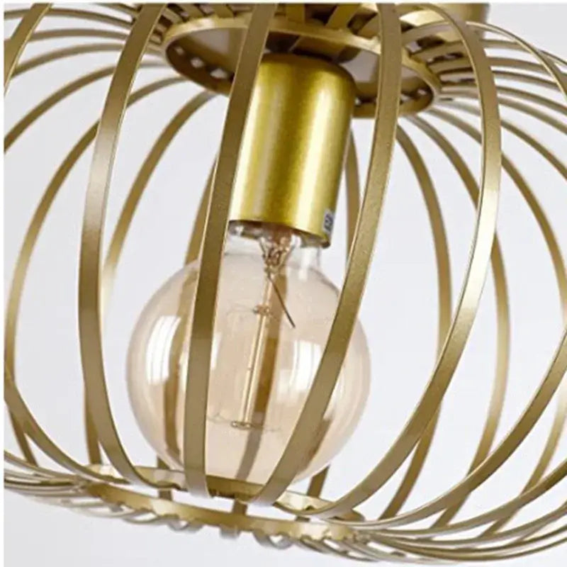Gold iron art ceiling light with wireframe design featuring a gold-toned metal cage pendant light with clear glass bulb