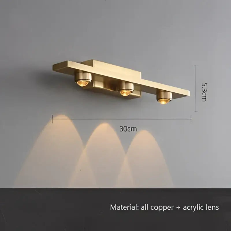 Brass-finished wall sconce with three warm-toned led spotlights and acrylic lenses from decorbites iron art mirror collection