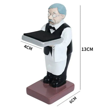 A miniature resin figurine of a vintage waiter with light blue hair holding a silver tray for bear statue watch rack