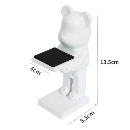 White bear statue watch rack with black rectangular surface held by outstretched arms for bedroom storage