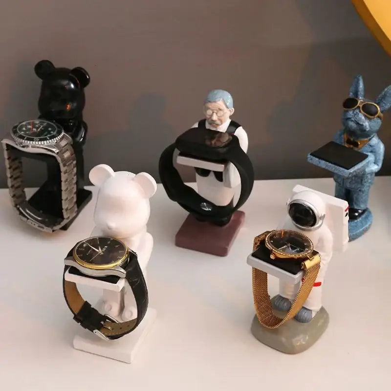 White bear statue watch stand holding black leather strap gold-toned wristwatch for bedroom storage use