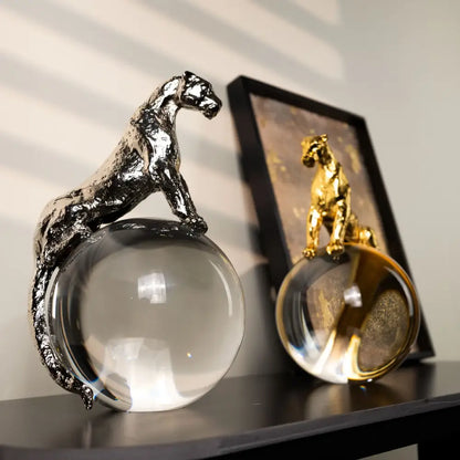 Shiny silver panther metal sculpture perched atop clear crystal ball for elegant living room decorbites leopard crystal display