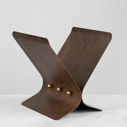 Dark wood magazine stand with curved design and gold-toned studs for elegant decorbites leopard crystal ball decor