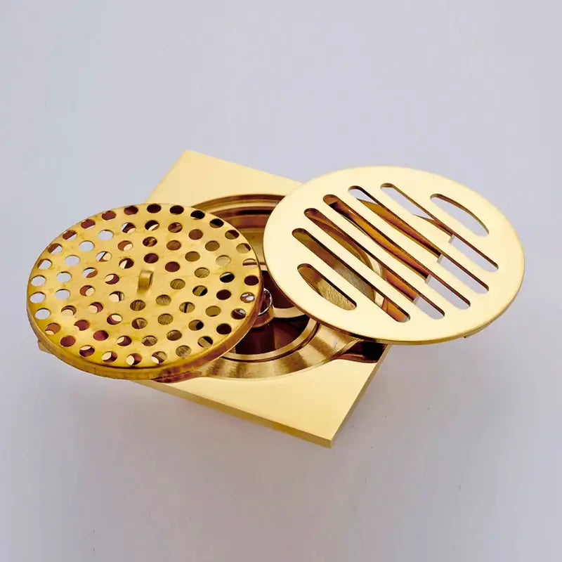 Gold square bathroom shower drain with interchangeable perforated grates featuring round and slotted openings decorbites gold square