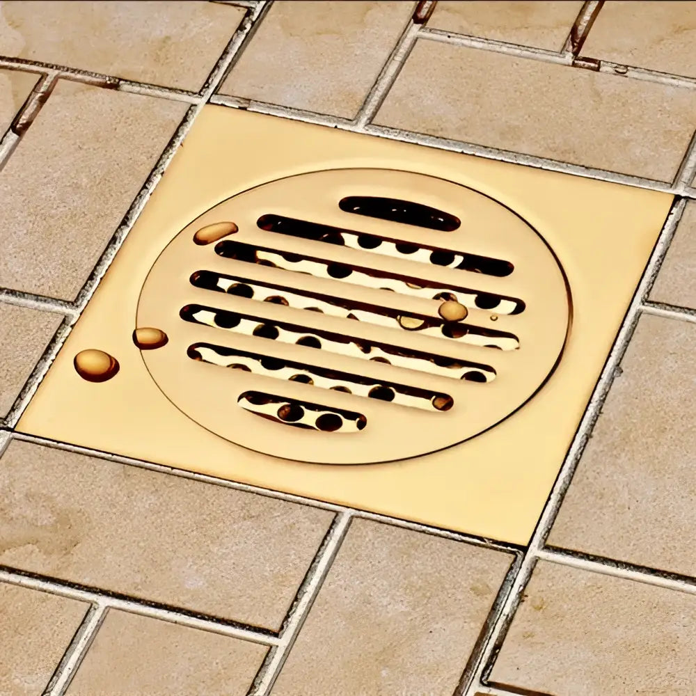 Gold-colored circular floor drain with horizontal slats and raised rim for decorbites gold square bathroom shower drain