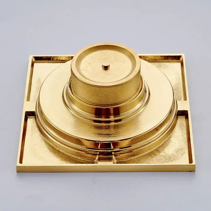 Golden brass decorbites gold square bathroom shower drain with square base and concentric circular tiers and interchangeable grates