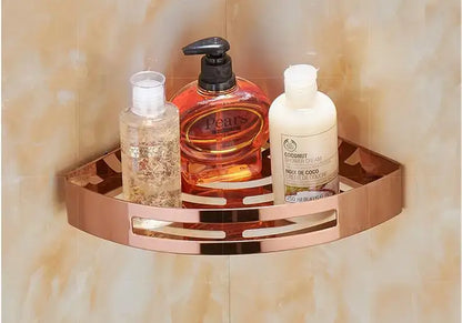 Rose gold stainless steel corner shelf with decorative cutouts holding three bathroom products by decorbites gold stainless