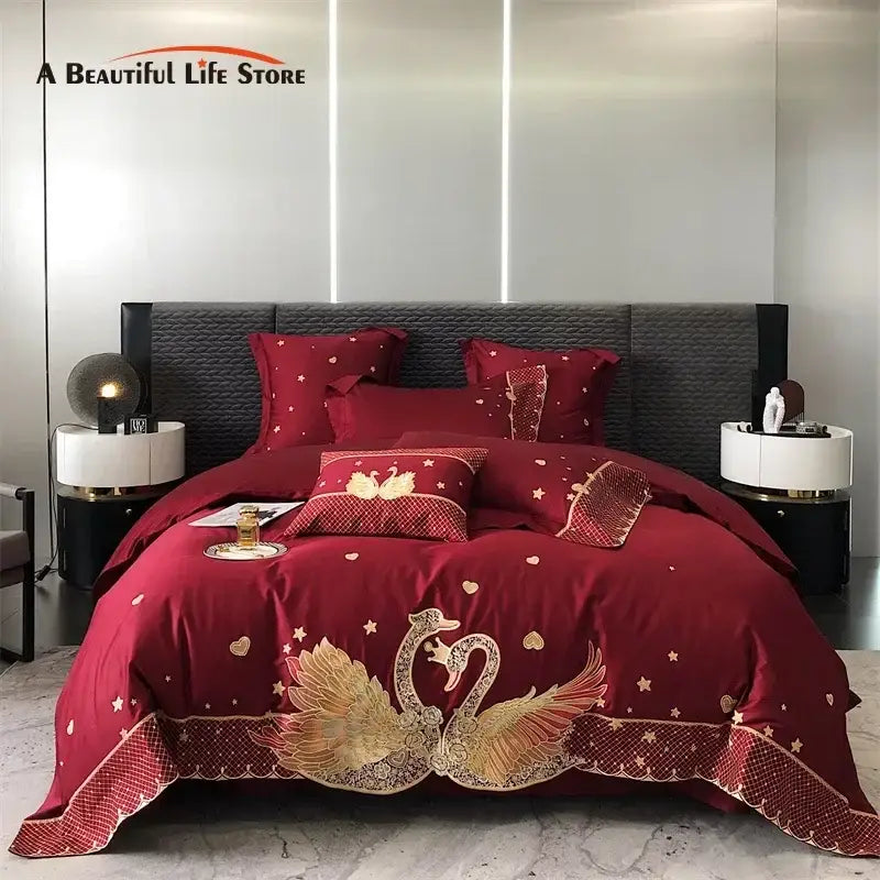 Red satin bedding set with intricate gold embroidered swan and star patterns and decorative lace trim for decorbites gold swan love