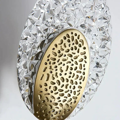 A sleek gold textured glass led wall lamp with faceted glass and brass interior for indoor lighting