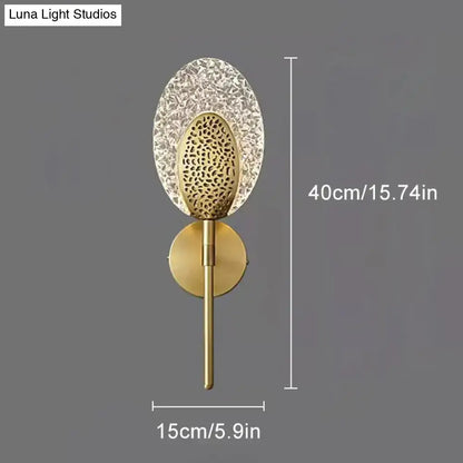 Gold textured glass led wall lamp with oval cut-out shade and brass base for indoor lighting in bedroom