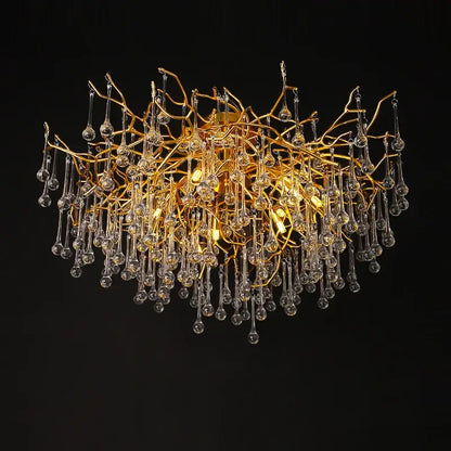 Gold tree branch chandelier featuring clear crystal droplets designed for elegant dining room lighting