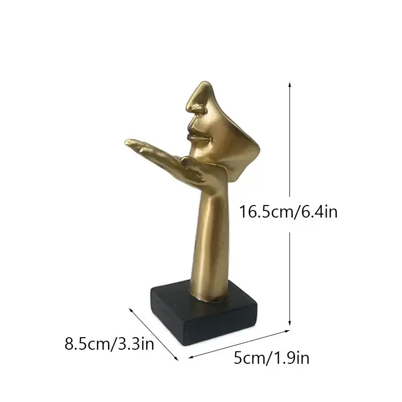 Golden metallic abstract mask statue featuring a stylized hand with face profile on black base for home office decor