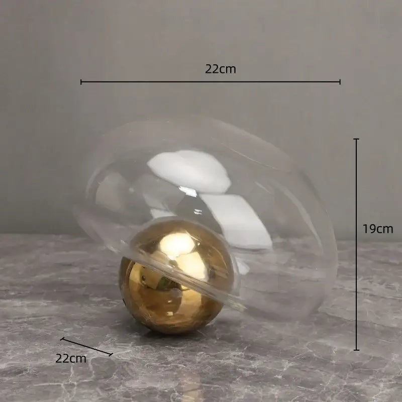 A sleek golden ball glass vase with a transparent dome and polished gold sphere for blue and gold hydroponic decorbites decor